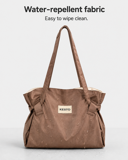 A brown water-repellent fabric tote bag with dual shoulder straps and a beige KESTO brand patch on the front, displayed against a light gray background with text reading 'Water-repellent fabric Easy to wipe clean.'.